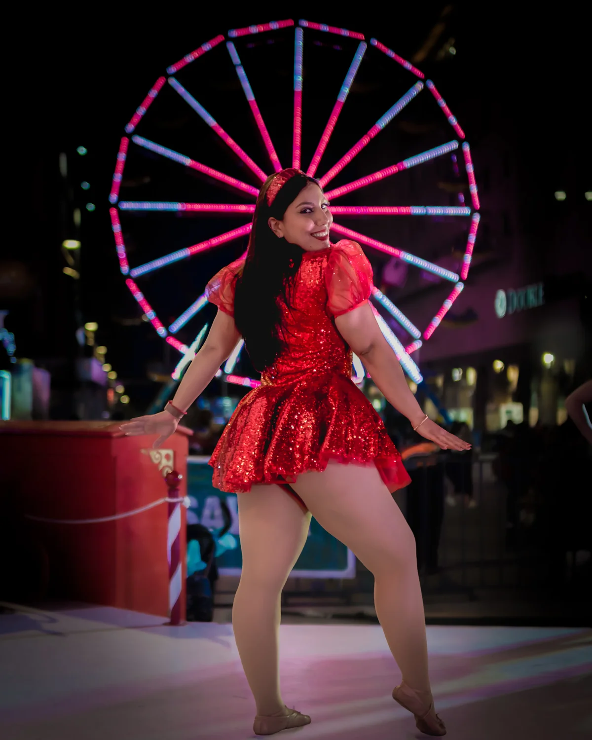 Bailarina con vestido rojo frente a la rueda de la fortuna iluminada en Navidad en el Centro de Guadalajara 2025 — Kaptur fotografía de evento